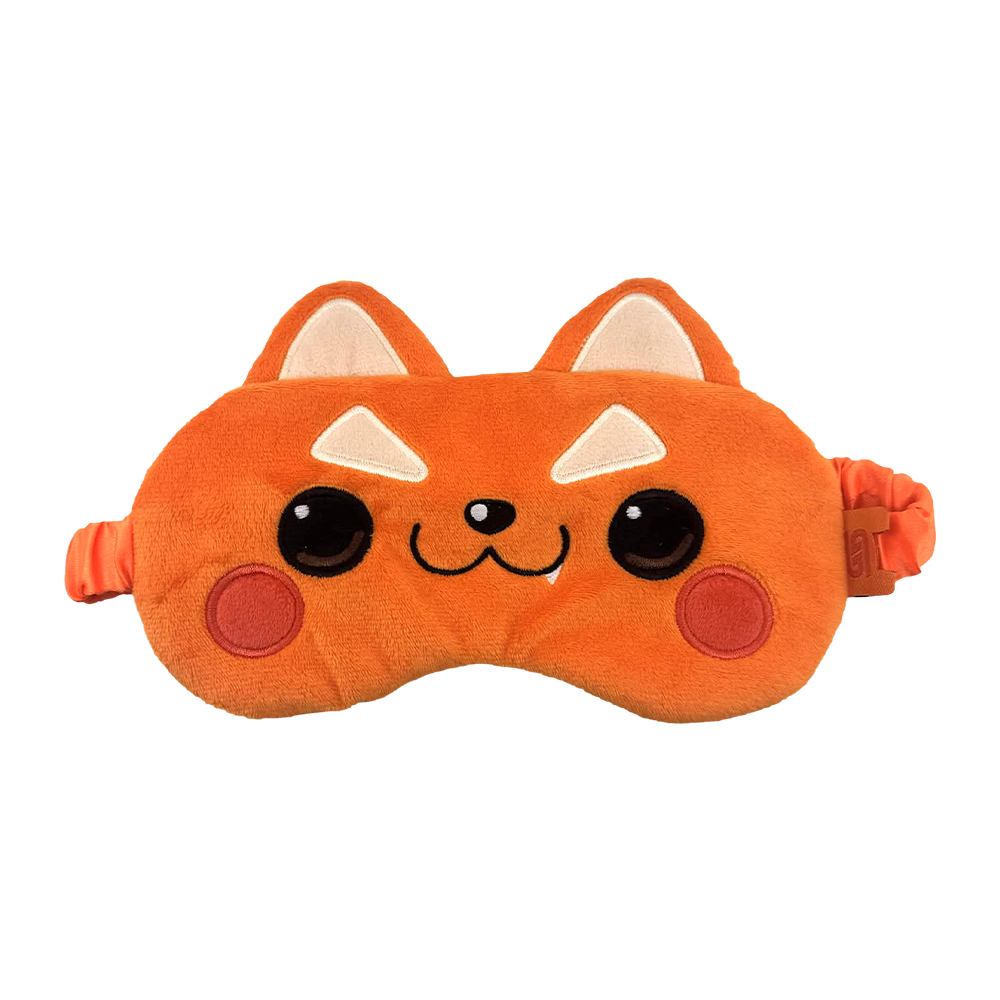 An orange plush sleep mask shaped like a cute cartoon fox face, with embroidered black eyes, a small black nose, white triangular ears, and red circular cheeks, shown on a plain white background.